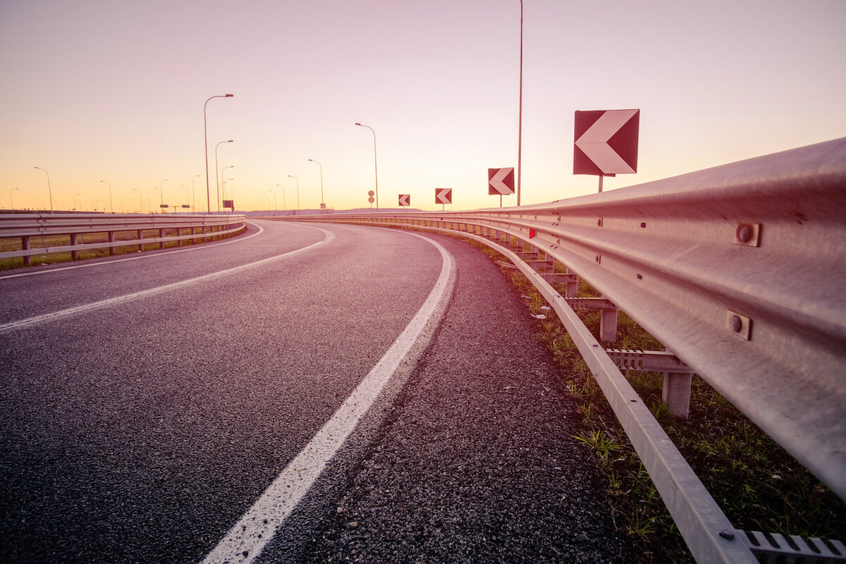 photo of a curve in the road with guard rails