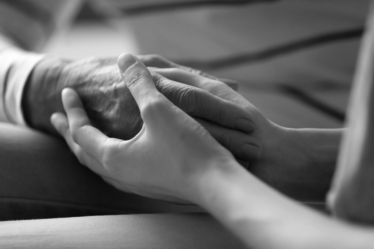 Photo of hands held comforting one another