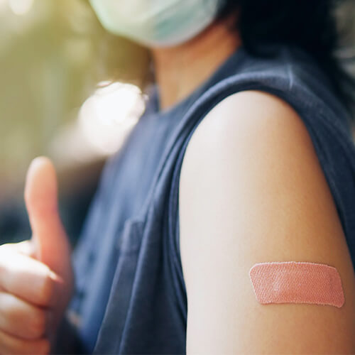 Photo of woman with a booster shot bandaid on her arm