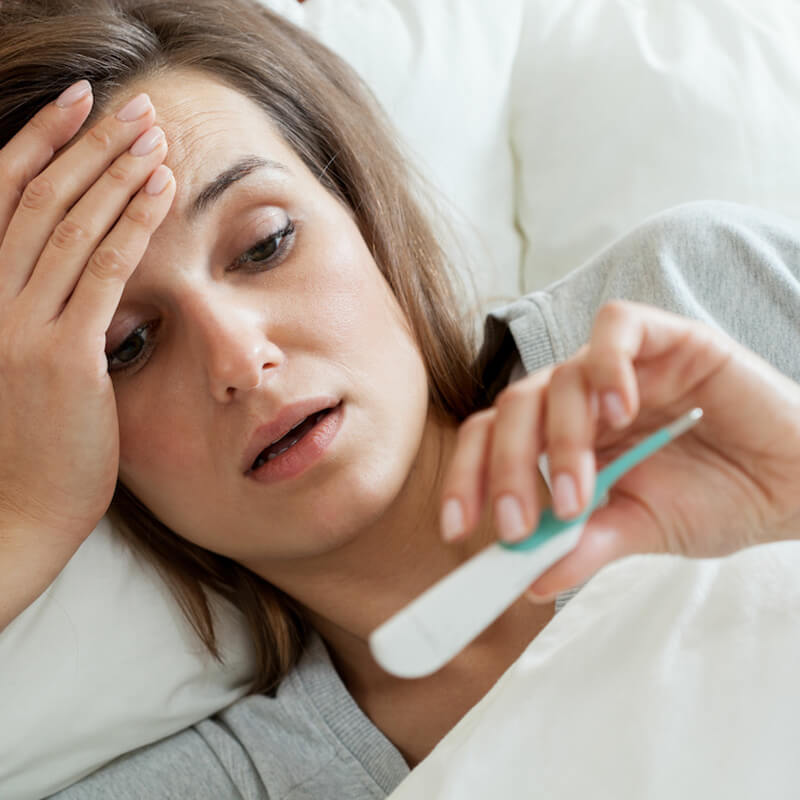 Photo of a woman with a thermometer