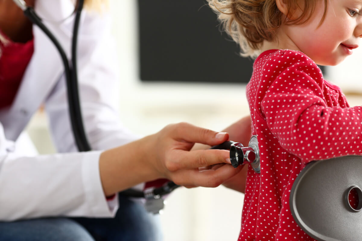 Photo of a child with doctor holding stethoscope