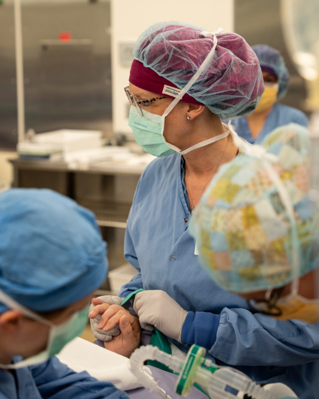 Photo of surgical nurse holding hand of patient