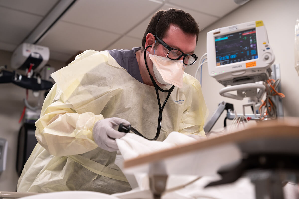 Photo of Adam Shapin, MD, tending to a patient