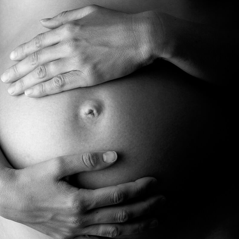 Photo of a mother with her hands on her pregnant belly