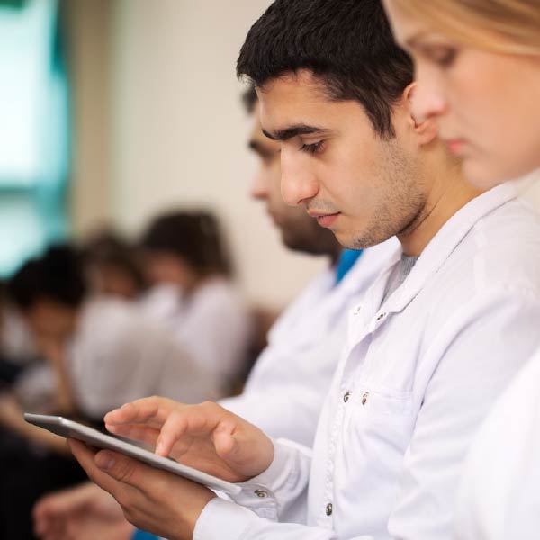 Photo of medical school students, one with a tablet