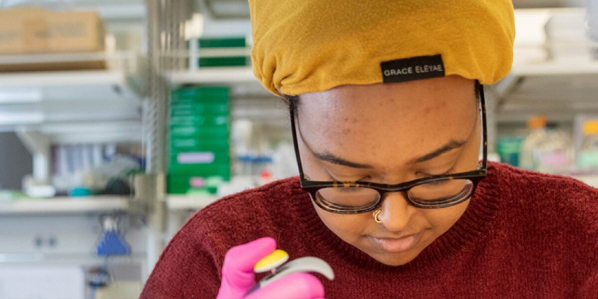 Hero photo of a University of Minnesota Medical School student with a yellow cap in a lab