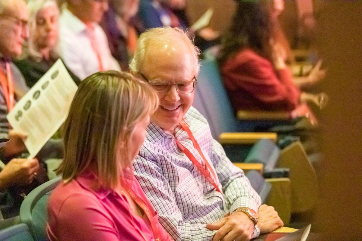 Colleagues talking in the audience at TEDxCentraCare