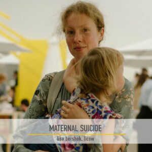 A mother holding her toddler in her arms in a busy outdoor market