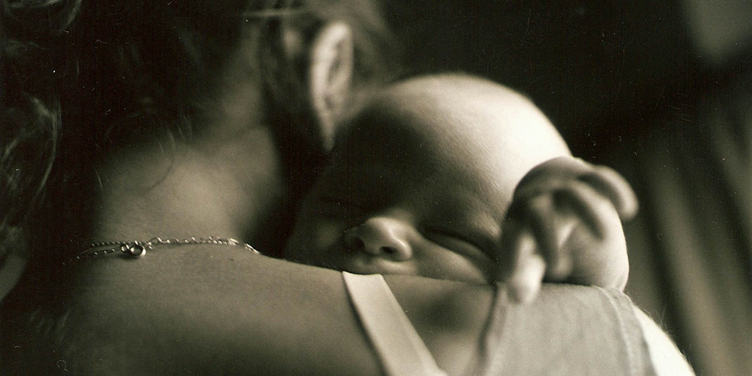 Over the shoulder view of a mother holding her young infant